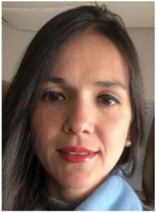 Portrait of a woman with straight dark hair and red lipstick wearing a light blue top