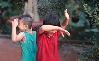 Two young children playing with water